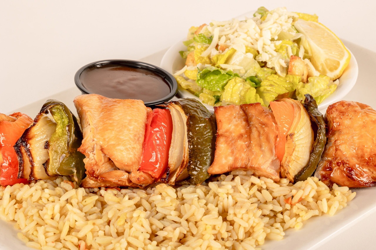 Brochette de poulet grillé sur riz, avec salade et sauce
