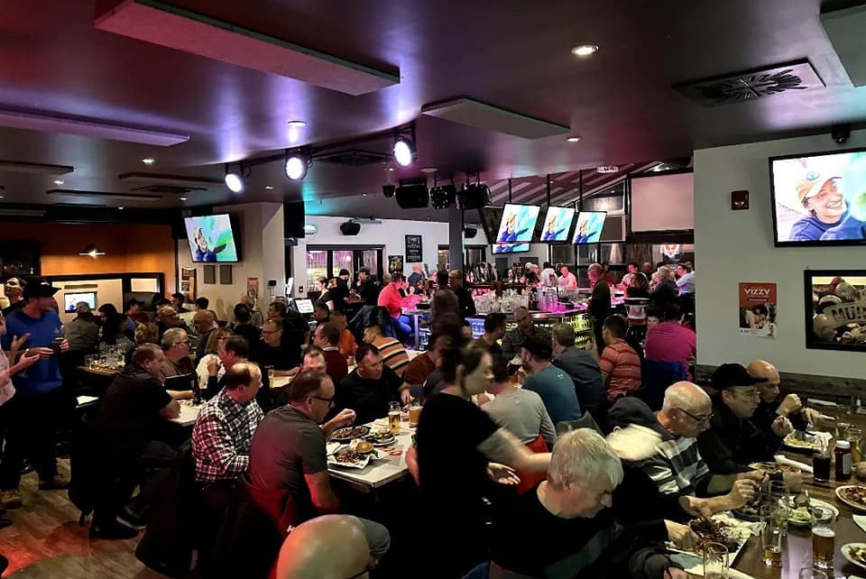 La salle du Stanley pleine : tables occupées, écrans allumés au-dessus du bar